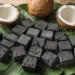 Eco friendly coconut shell charcoal briquettes on a natural green leaf background representing sustainability